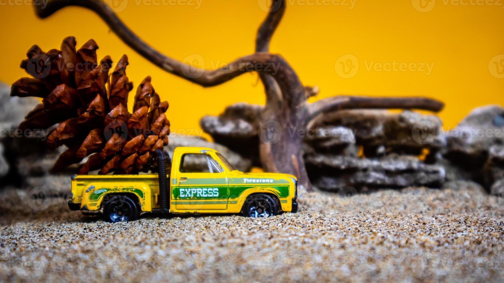 toy car hauling pinecones on an orange background photo
