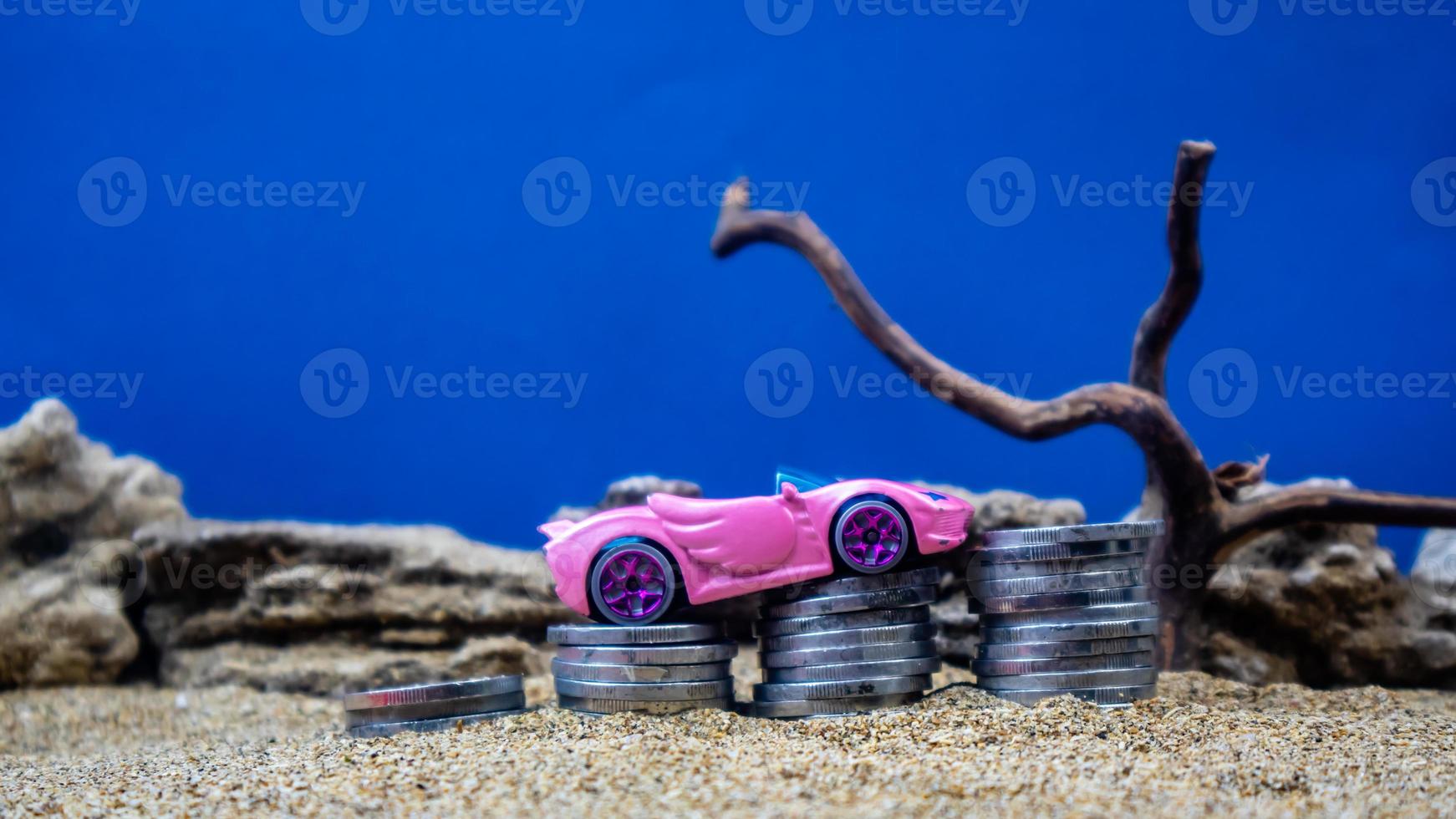 minahasa, Indonesia  January 2023, toy car on a pile of coins, saving for the future, managing successful transportation business technology concept photo