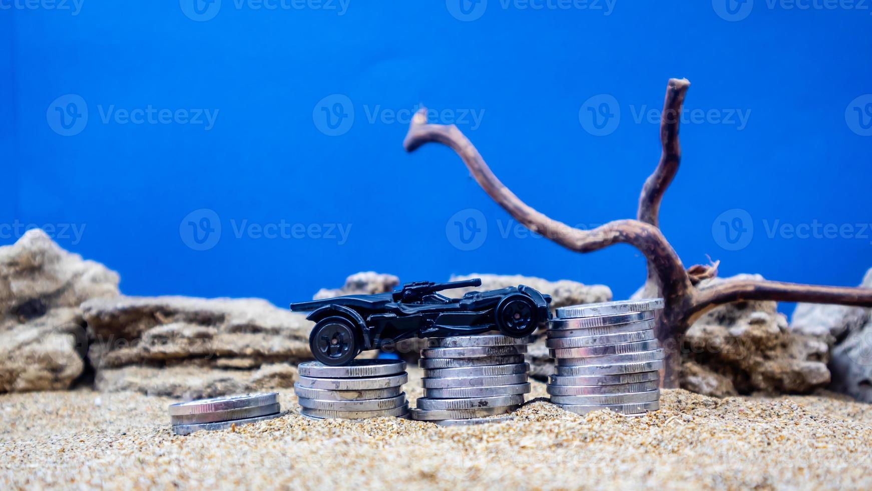 minahasa, Indonesia  January 2023, toy car on a pile of coins, saving for the future, managing successful transportation business technology concept photo