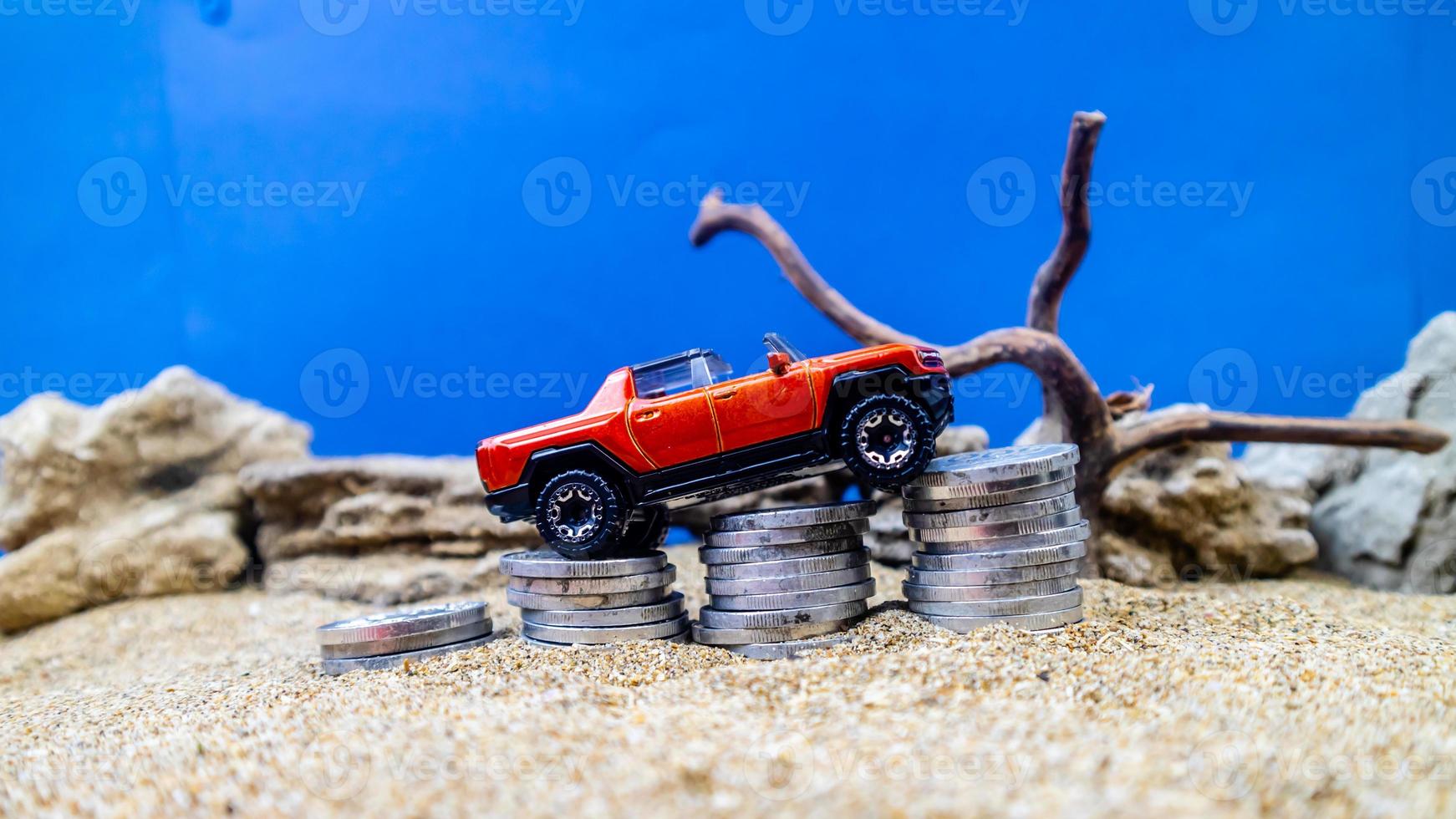 minahasa, Indonesia  January 2023, toy car on a pile of coins, saving for the future, managing successful transportation business technology concept photo