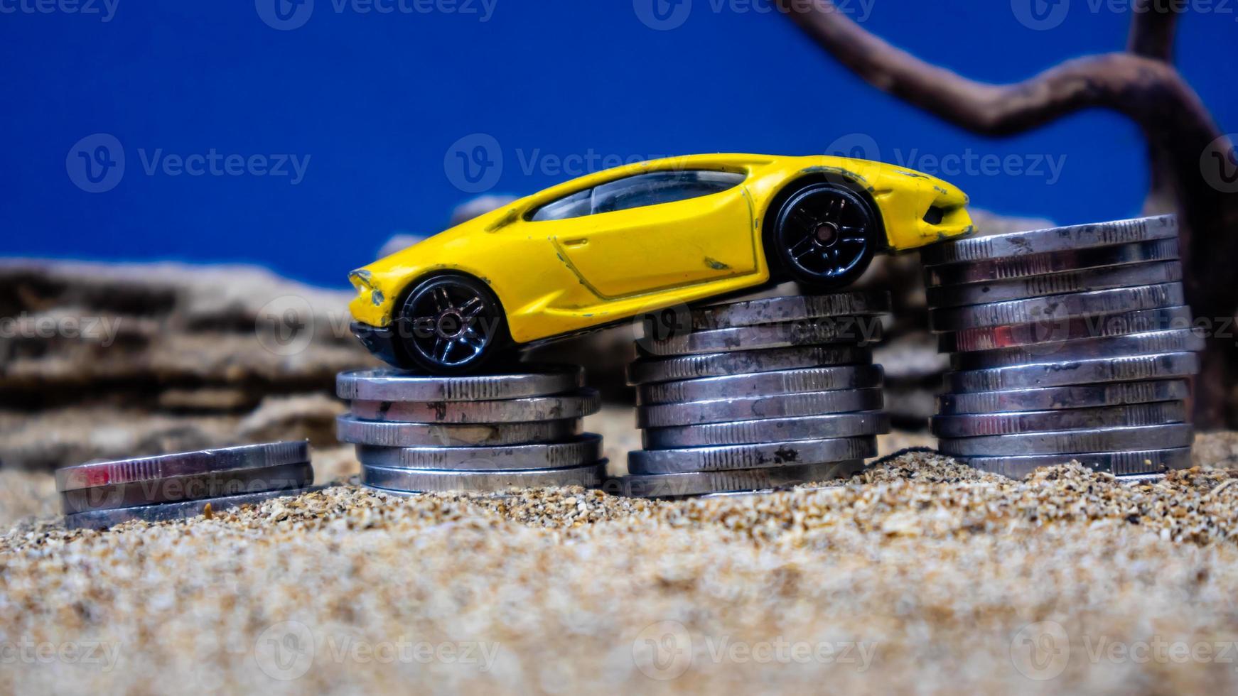 minahasa, Indonesia  January 2023, toy car on a pile of coins, saving for the future, managing successful transportation business technology concept photo