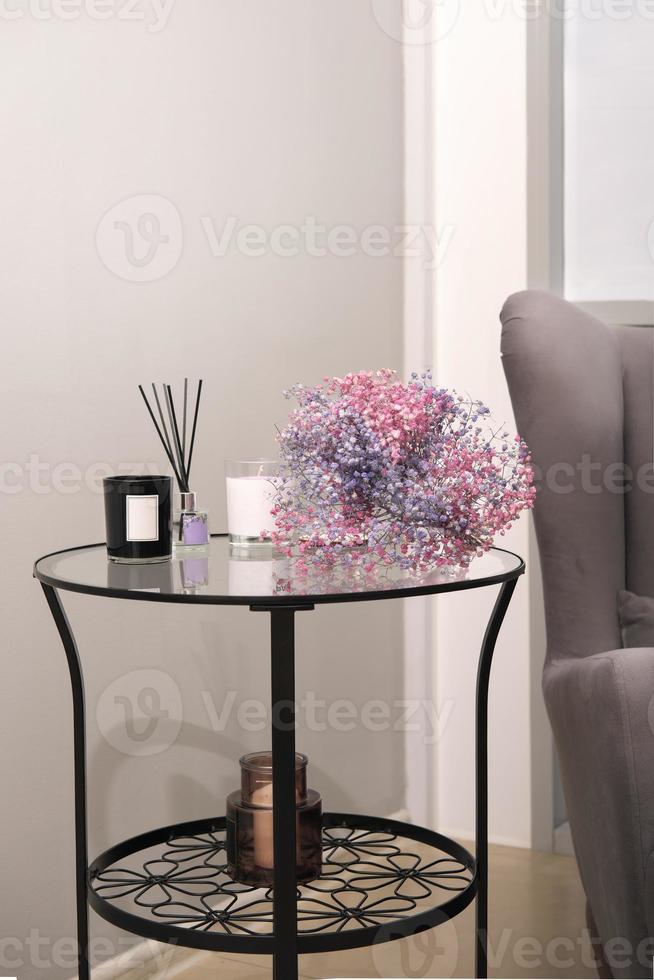 details of modern trendy interior, metallic and glass table with flowers, candles and decor. cozy place in apartment. photo