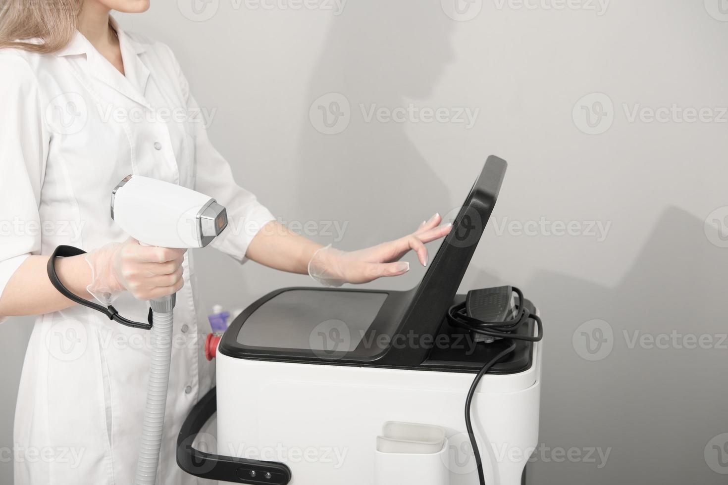 mujer vistiendo blanco médico uniforme participación láser depilación máquina dispositivo. belleza y protección de la piel con diodo láser. foto