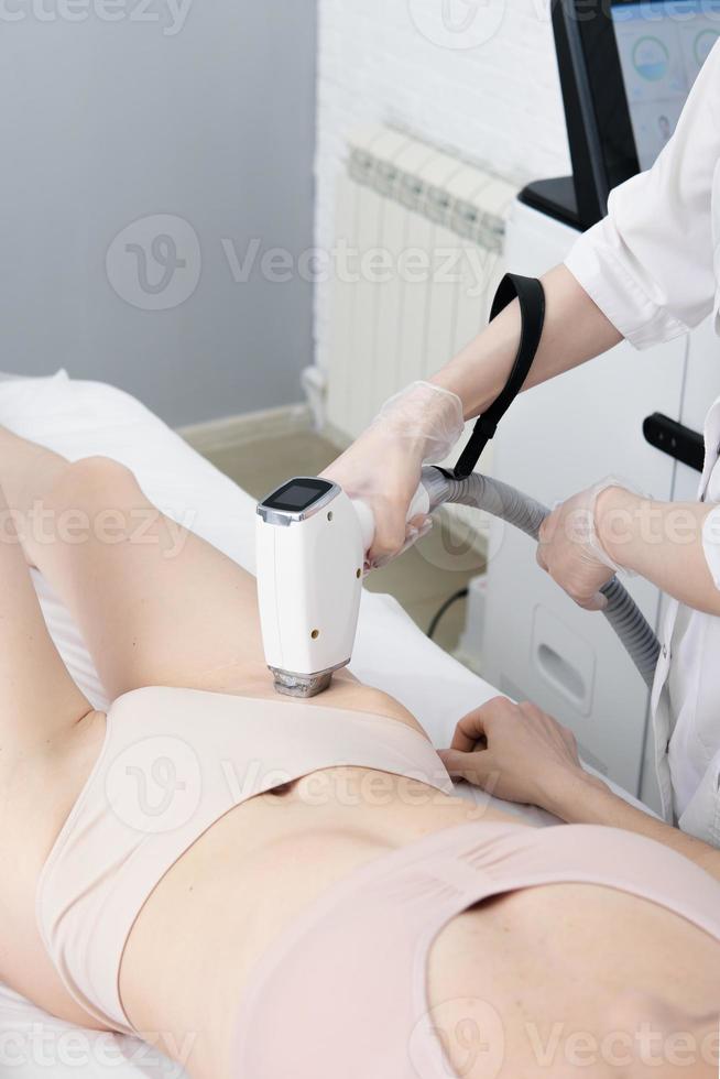 Hair removal bikini area. Beautician makes the procedure of laser body hair removal.vertical. beauty salon photo