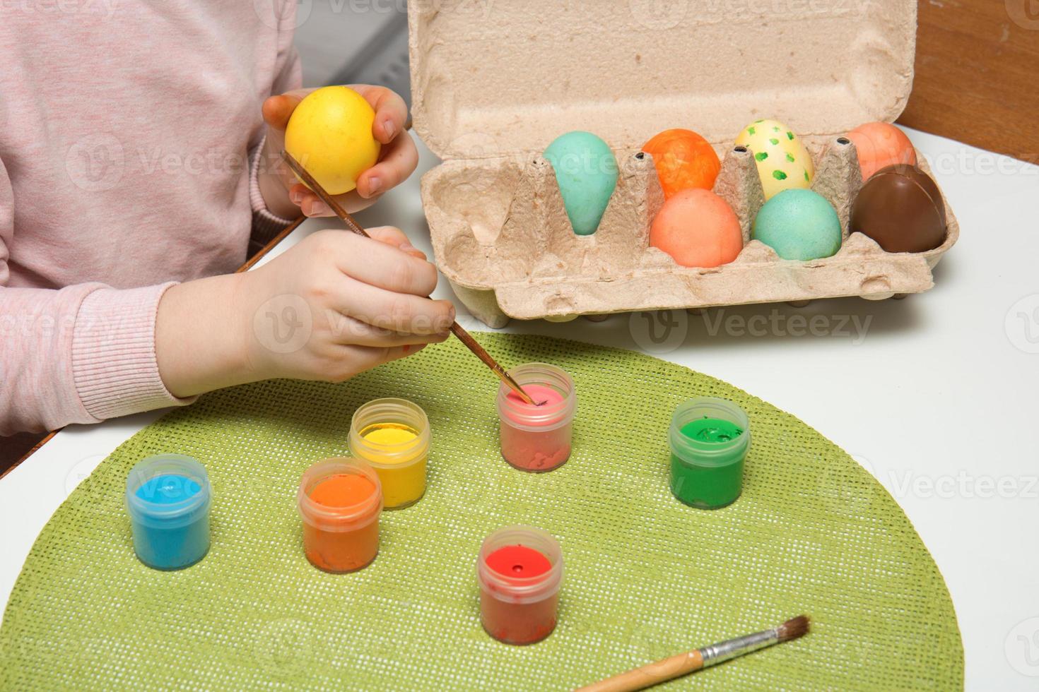 children's hands paint easter eggs with paints, easter content photo