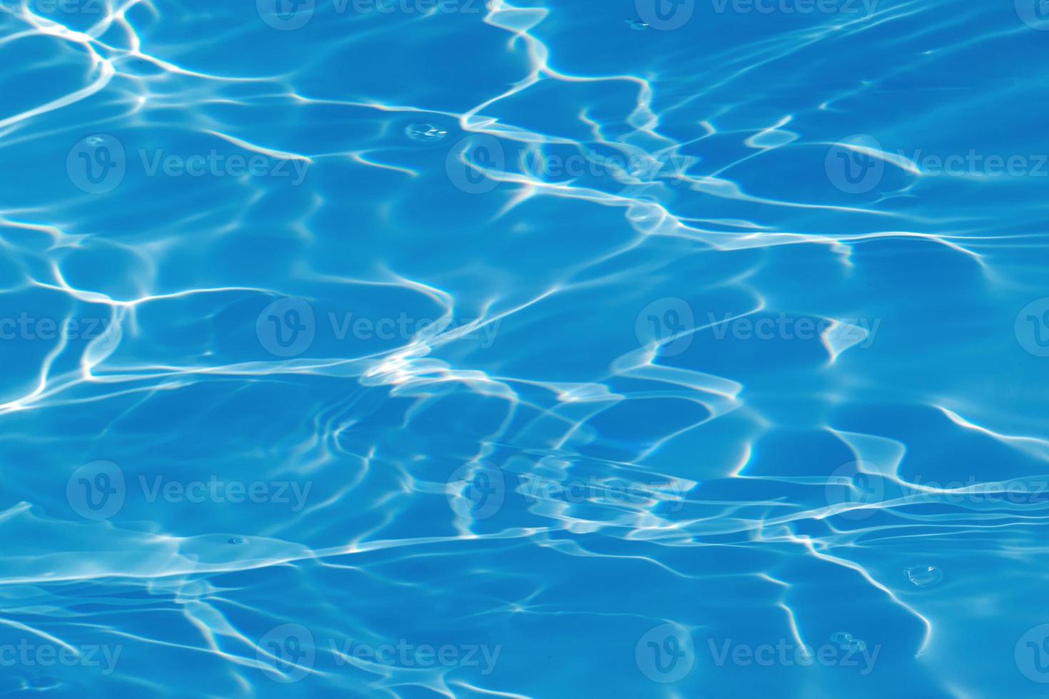 Defocus blurred transparent blue colored clear calm water surface texture with splashes and bubbles. Trendy abstract nature background. Water waves in sunlight with copy space. Blue watercolor shining photo