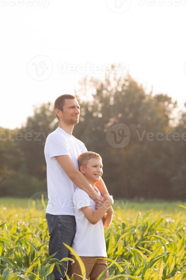 Cute boy hugs his dad at sunset. White T-shirts photo