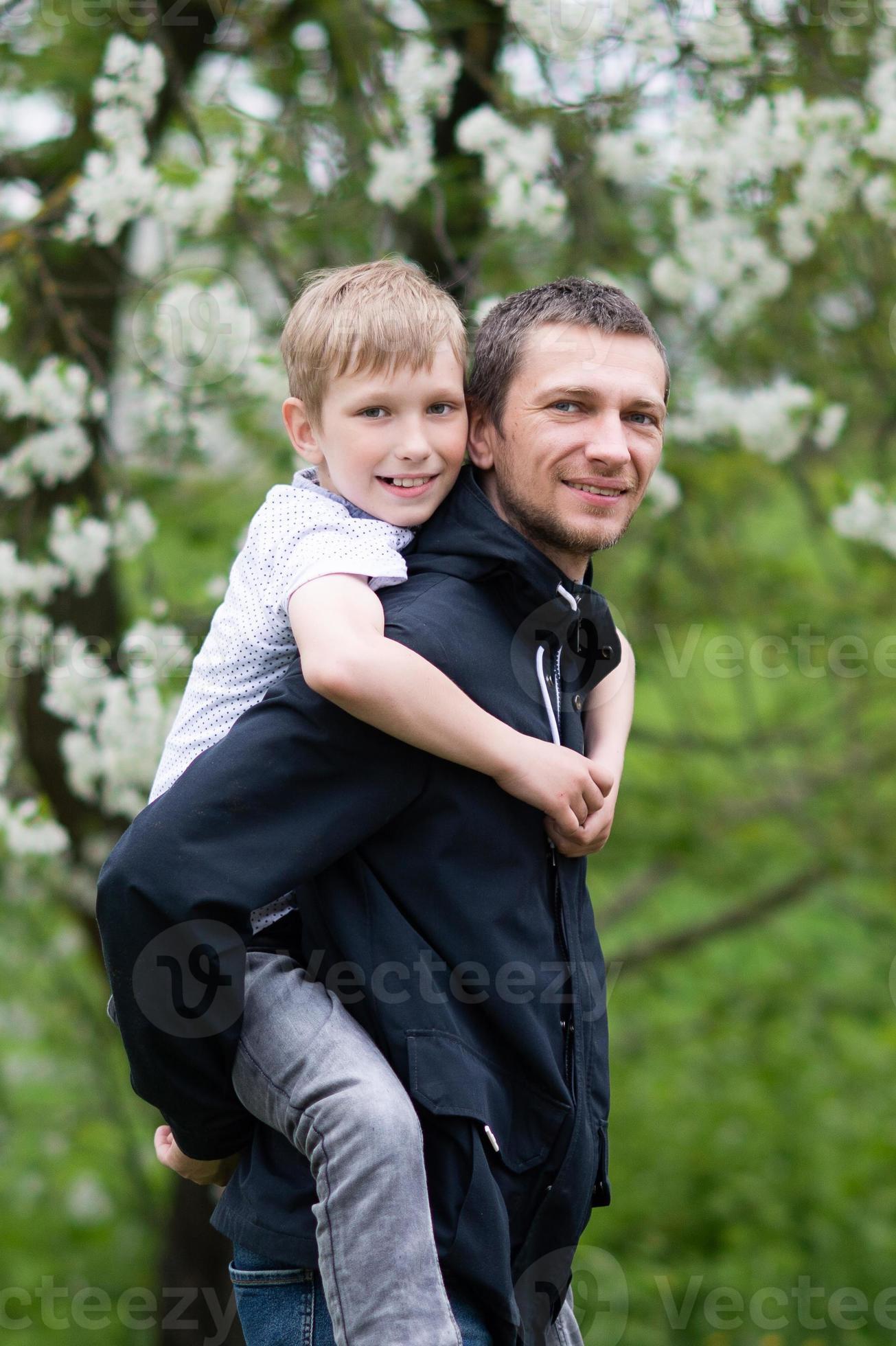 The boy is sitting on Dad