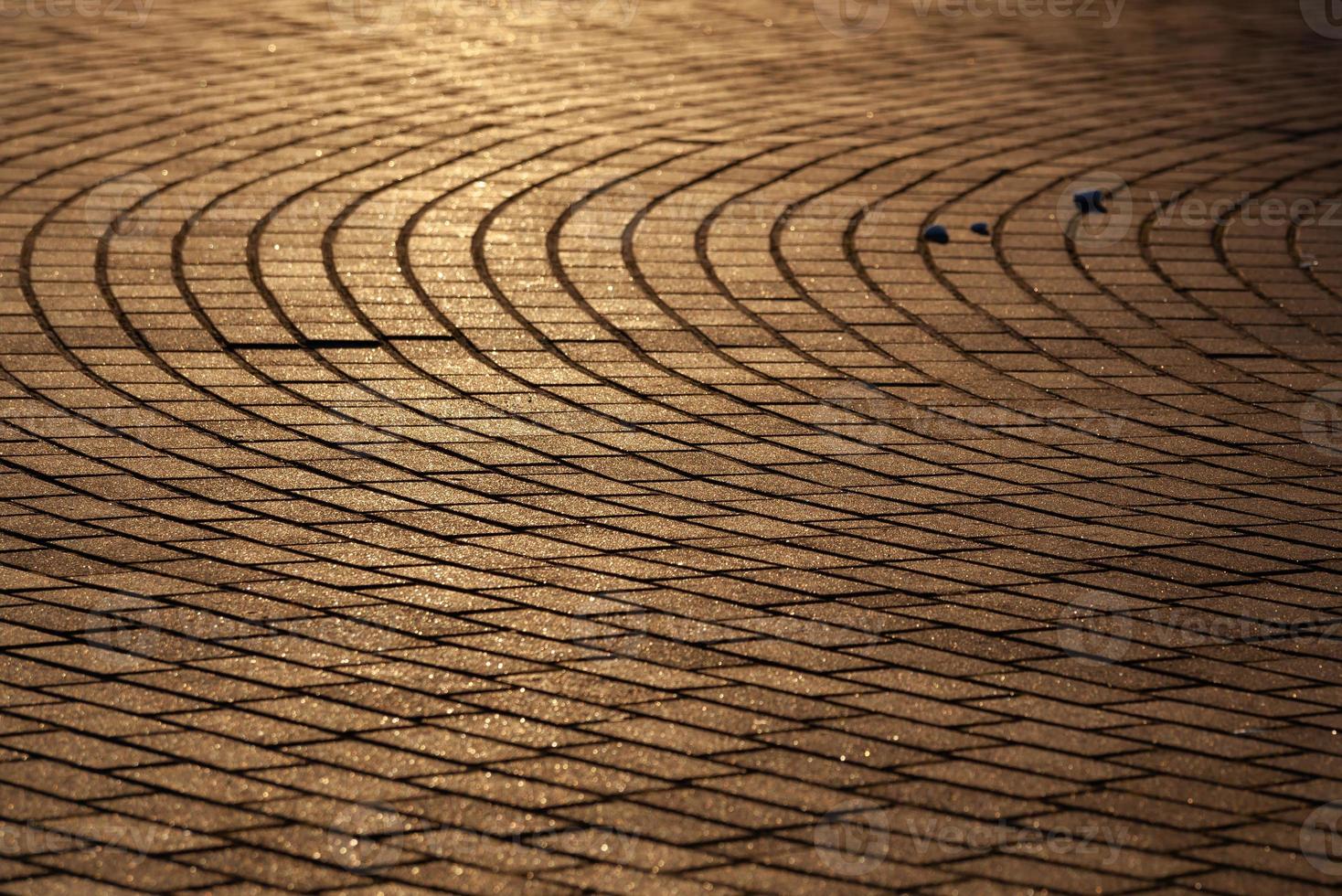 The texture of the sidewalk street in the sunlight. Brown rectangular tiles in perspective. Background. Horizontal. photo