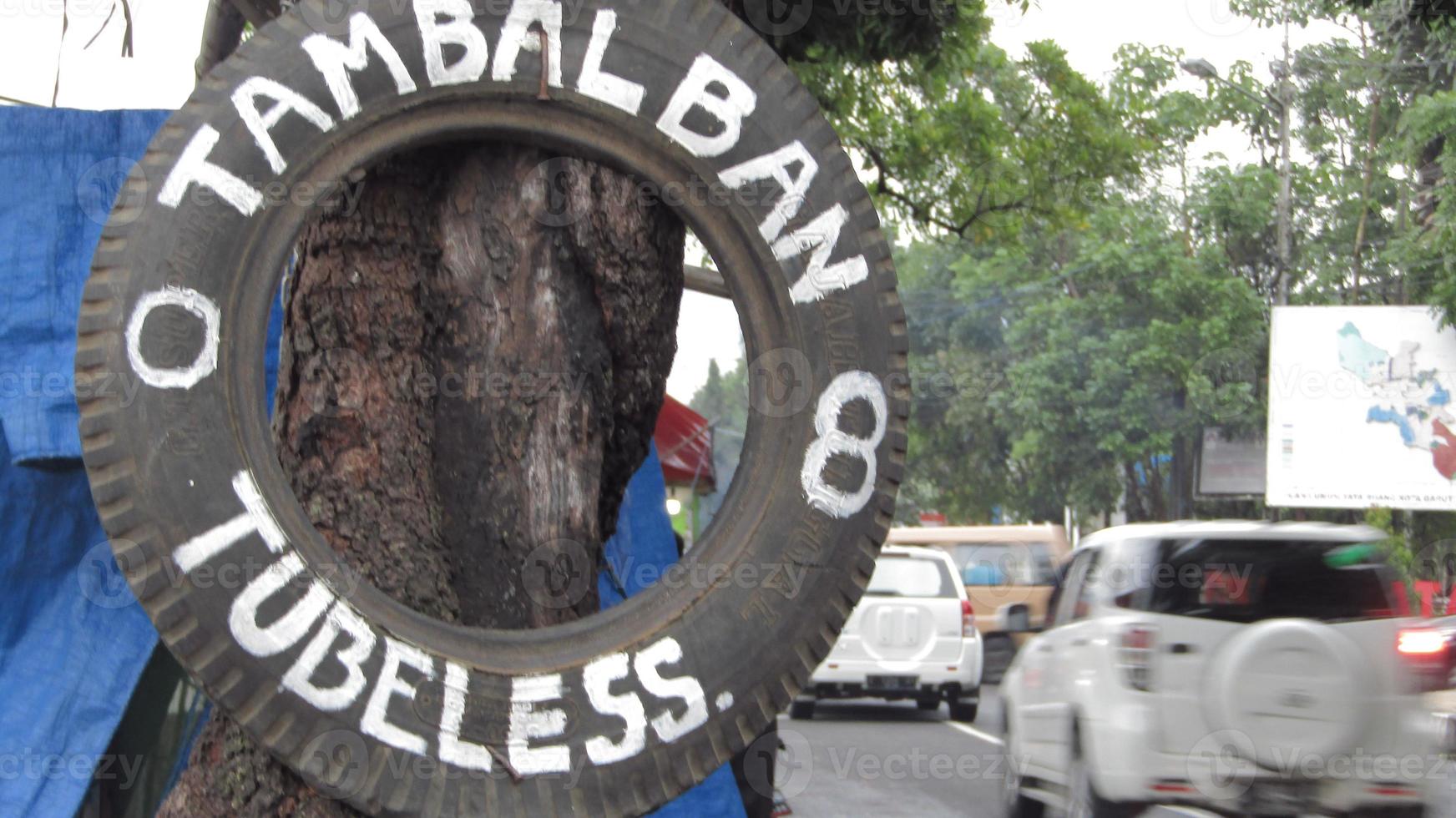 tambal ban sign on the tree photo