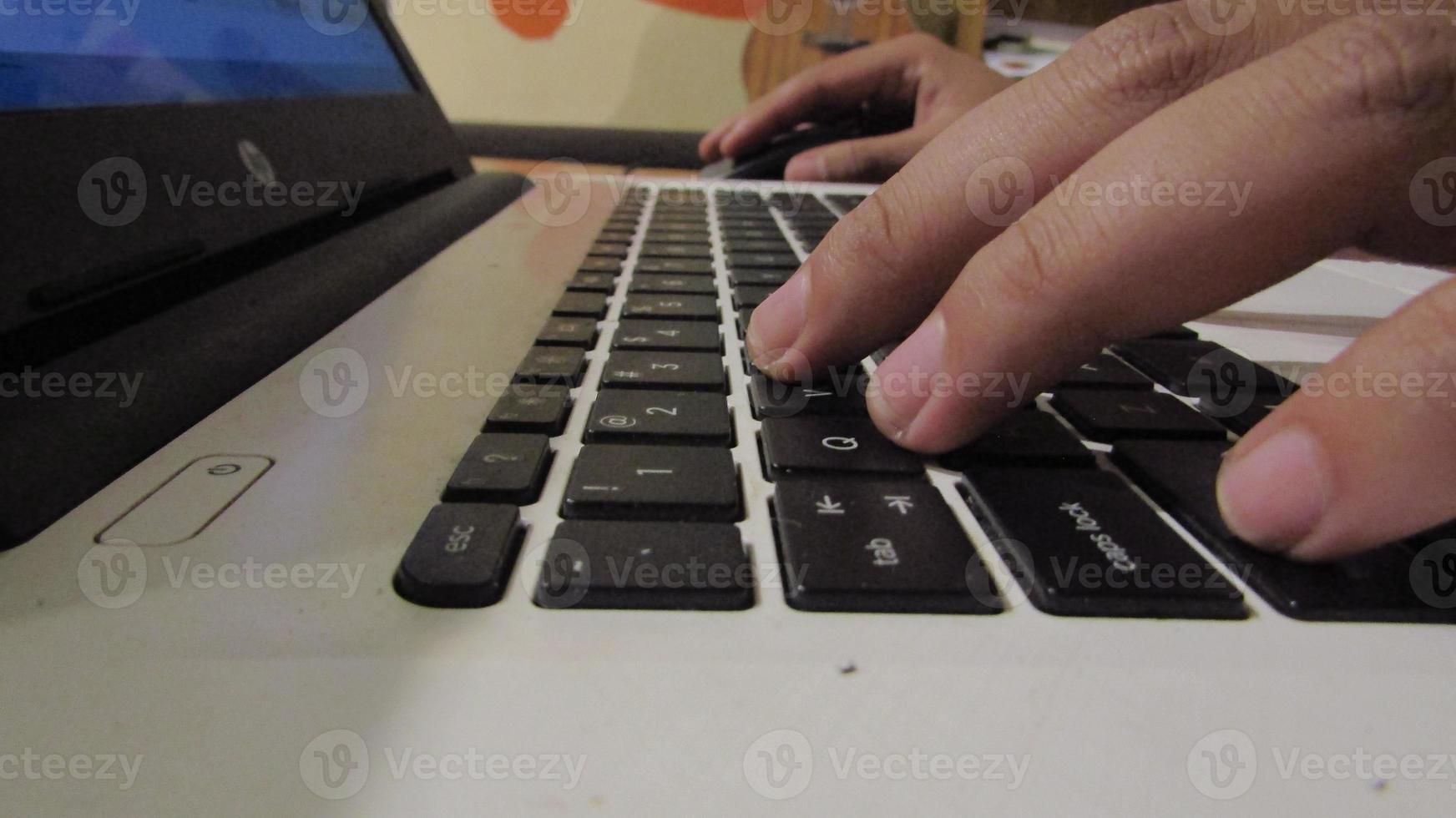 persona de libre dedicación utilizando ordenador portátil mecanografía en teclado trabajando cuaderno foto
