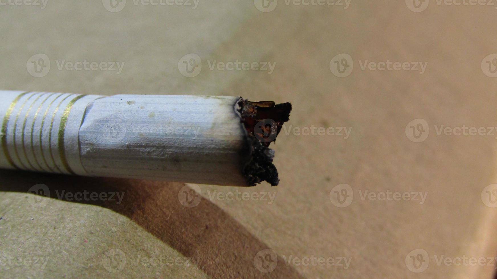 white cigarette butt burnt on the floor photo