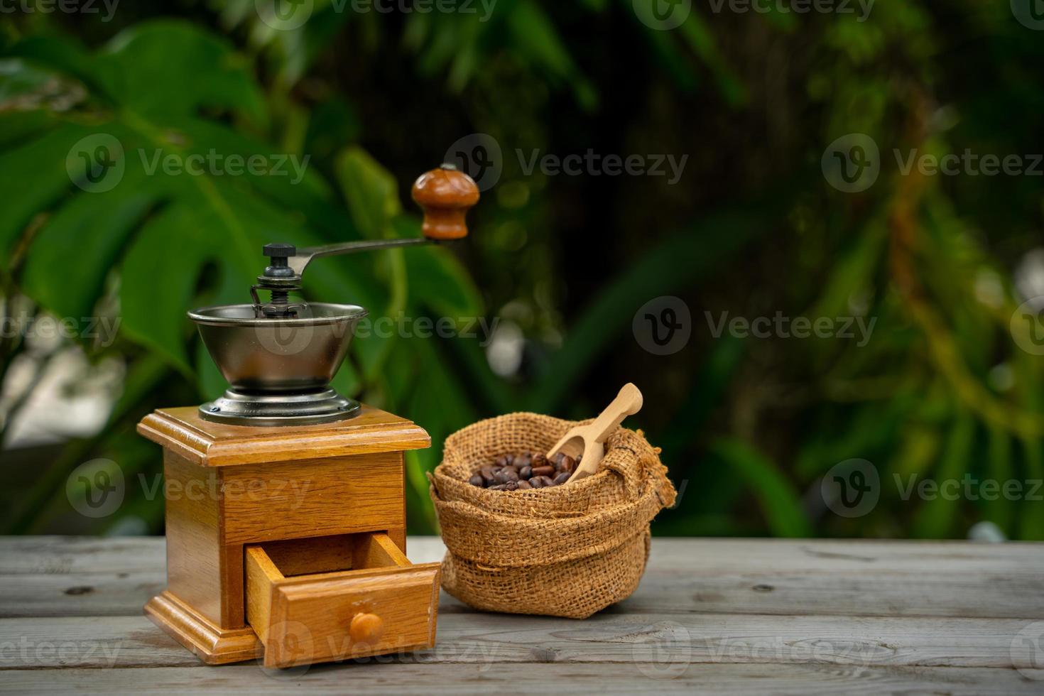 Vintage coffee grinder, Old retro hand-operated wooden and metal coffee grinder.Manual coffee grinder for grinding coffee beans on the old wooden background. photo