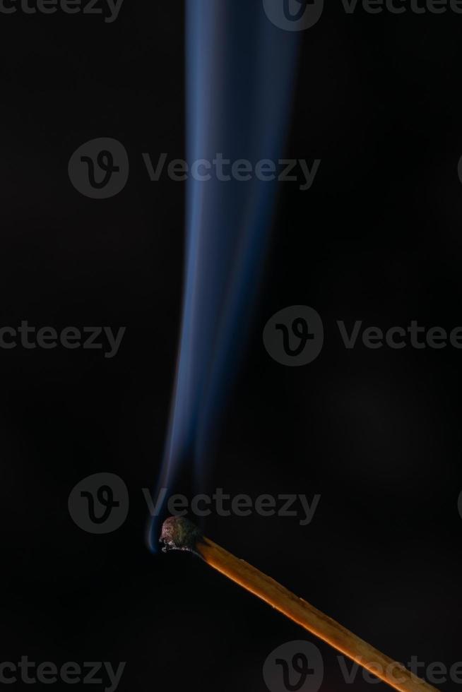 Smoke from burning matchsticks on a black background photo