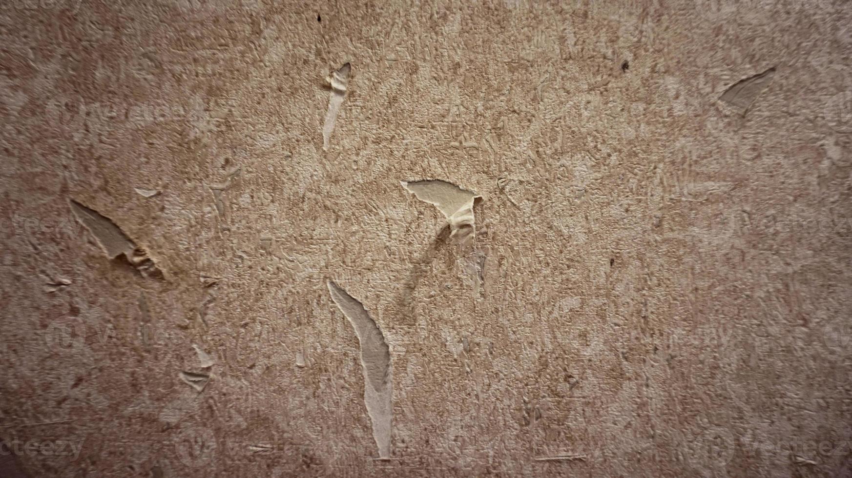 Close up of torn or ripped wallpaper. Hole in the wallpaper on the wall. Old faded floral wallpaper teared down or peeling off walls of the house for general background. Front view close up details. photo