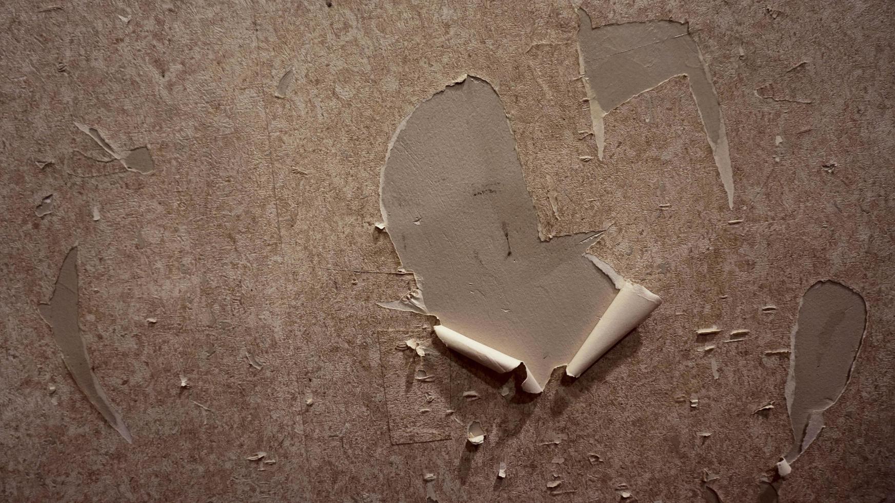 Close up of torn or ripped wallpaper. Hole in the wallpaper on the wall