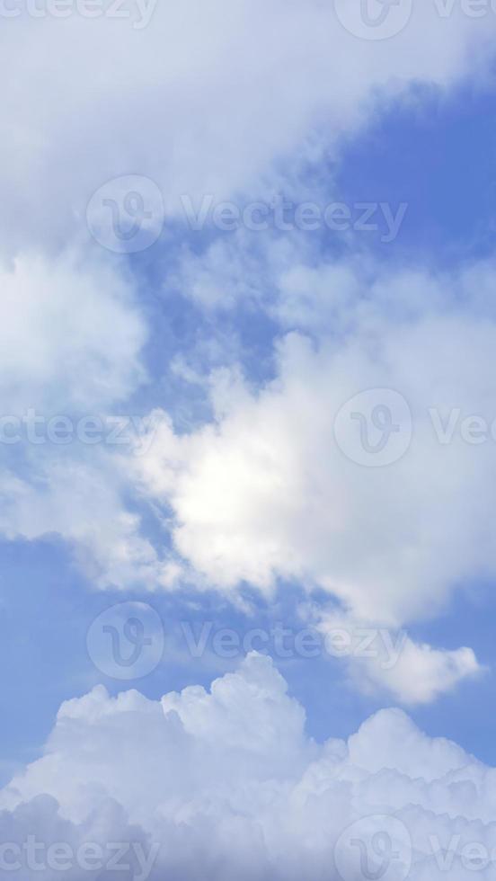 Fluffy white clouds in the soft blue sky, vertical image, sky wallpaper, nature background, backdrop, Pastel tone photo