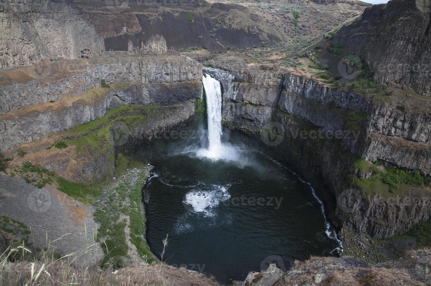 Waterfall created by river in the canyon falling to the deep pond photo