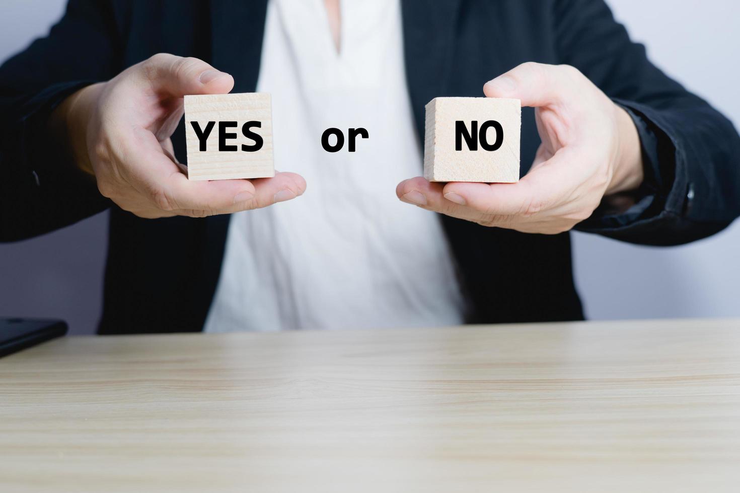 businessman is selecting a block that has the word yes or no on it. deciding Think with yes or no options. Business options for difficult situations yes or no. photo