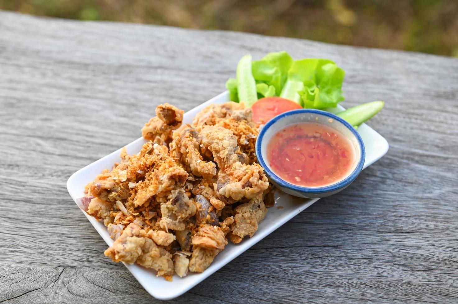 frito Cerdo intestino con ajo con salsa en plato - Cerdo menudencias tailandés comida o meriendas foto