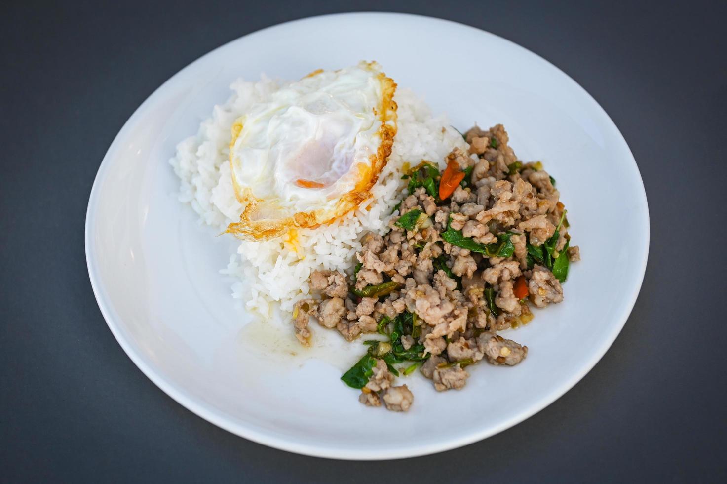 holy basil minced pork, Stir fried Thai basil with minced pork and a fried egg on white plate photo