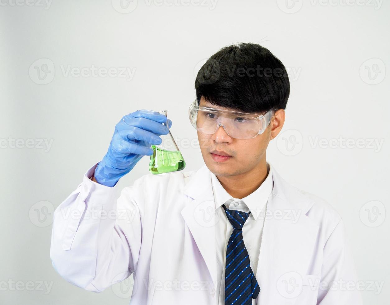 asiático hombre estudiante científico o médico en reactivo mezcla laboratorio en un Ciencias investigación laboratorio con prueba tubos de varios tamaños en el piso en laboratorio química laboratorio blanco antecedentes. foto