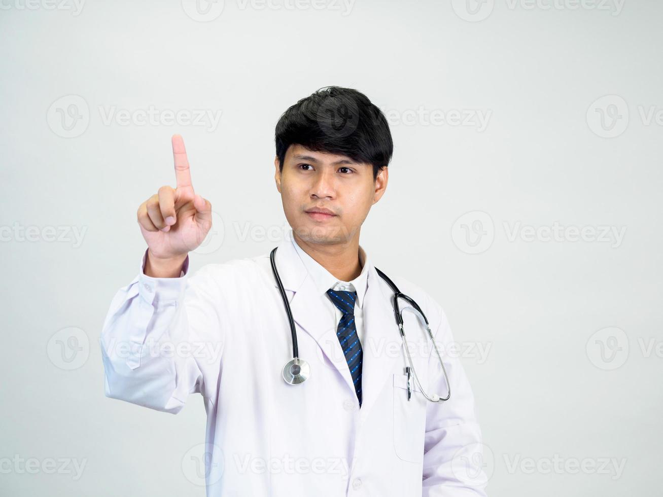 Asian man student scientist or doctor one person, wearing a white gown, standing, looking and smiling, white background with a stethoscope auscultating the heart around his neck. photo