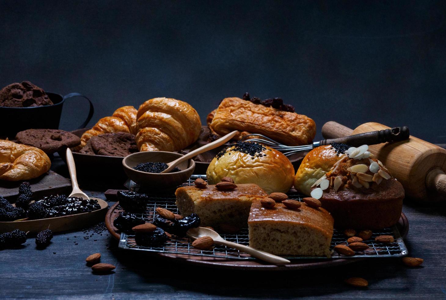 vista superior pan fresco pasas marrón panadería de sésamo hecha de harina de trigo comida casera adecuada para una alimentación saludable en el piso de la mesa de madera fondo oscuro rústico negro foto