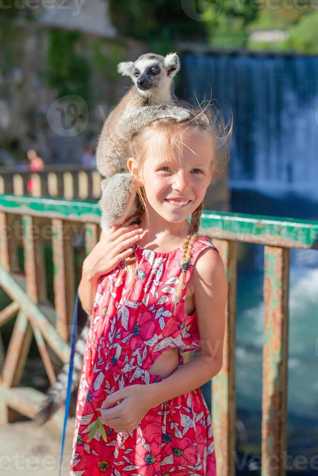 Little girl with lemur photo