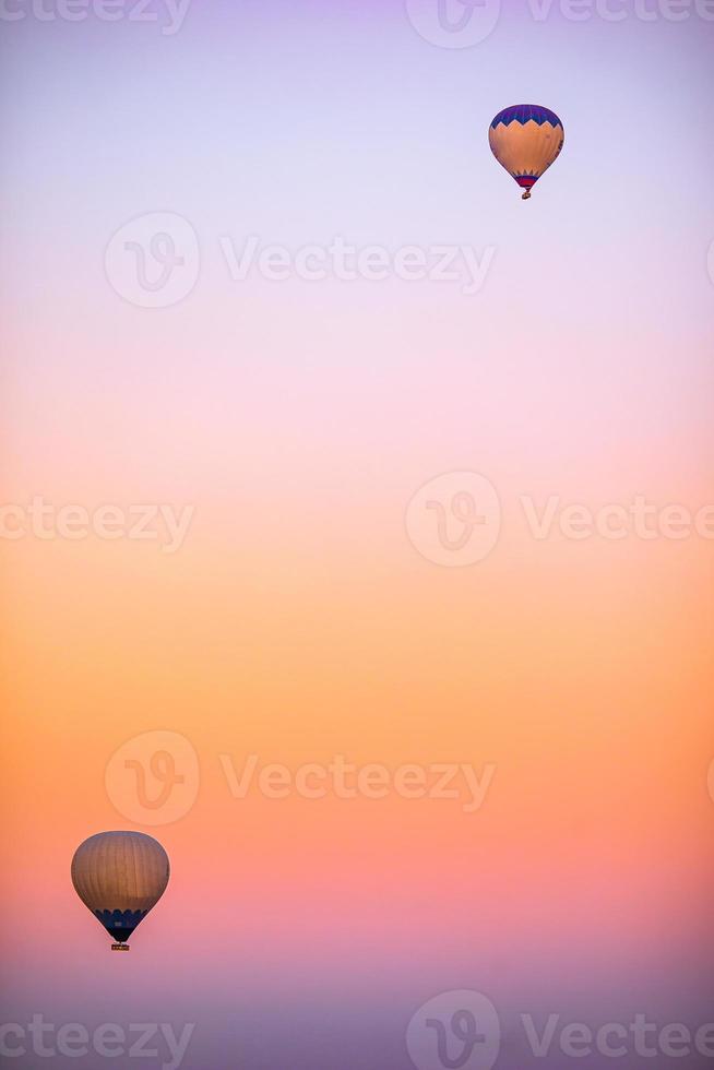 Hot air balloon flying over rocky landscapes in Cappadocia with beautiful sky on background photo