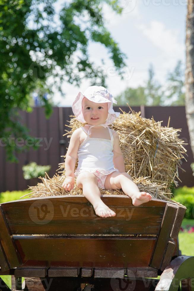 Pretty little girl sitting on a carriage photo
