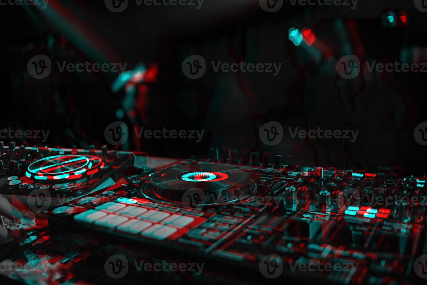 DJ console for mixing music with blurry people dancing at a nightclub party. Black and white with 3D glitch virtual reality effect photo