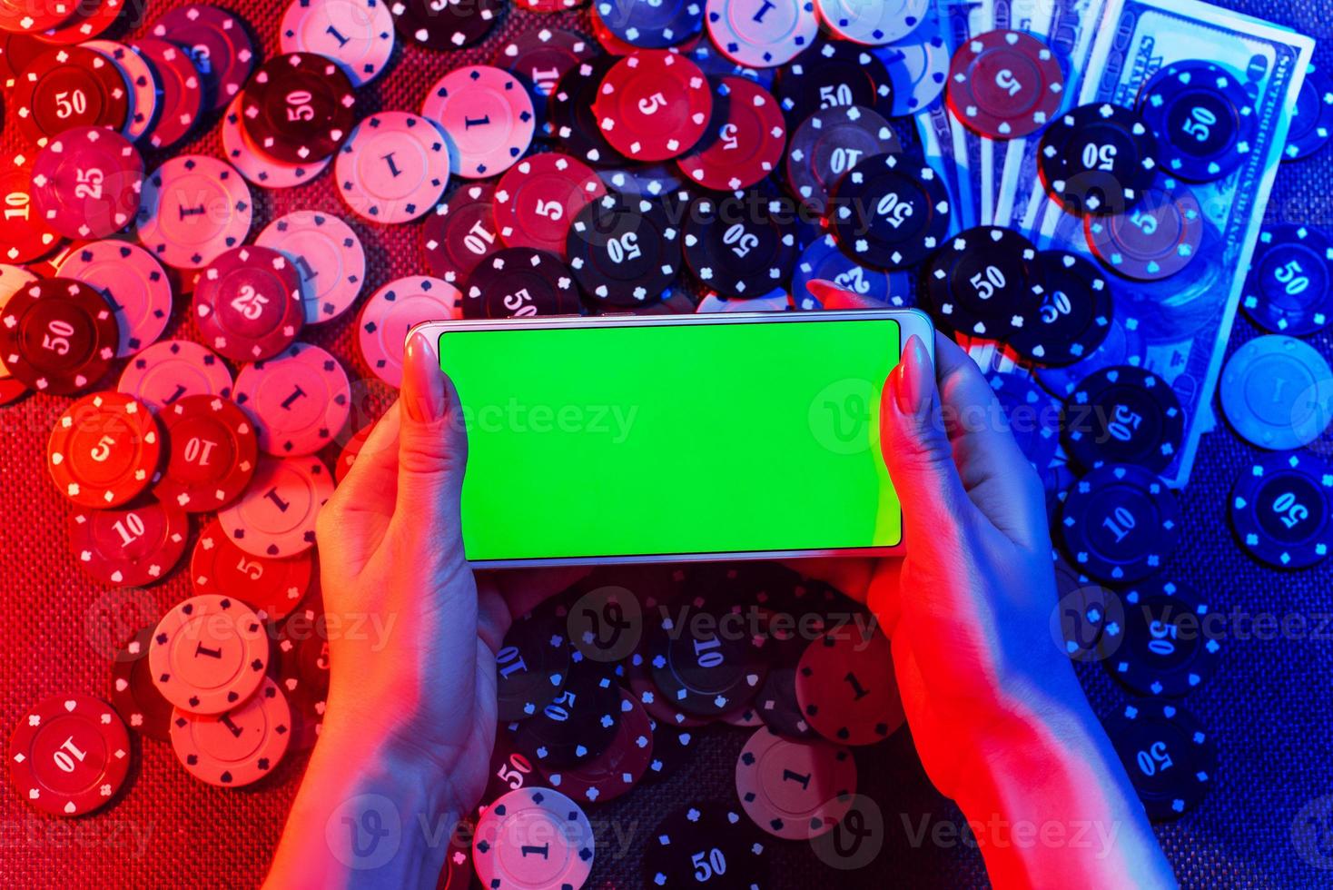 The concept of an online casino playing cards, betting chips and a smartphone with a copy space in women's hands. Top view. Smoke added to the photo