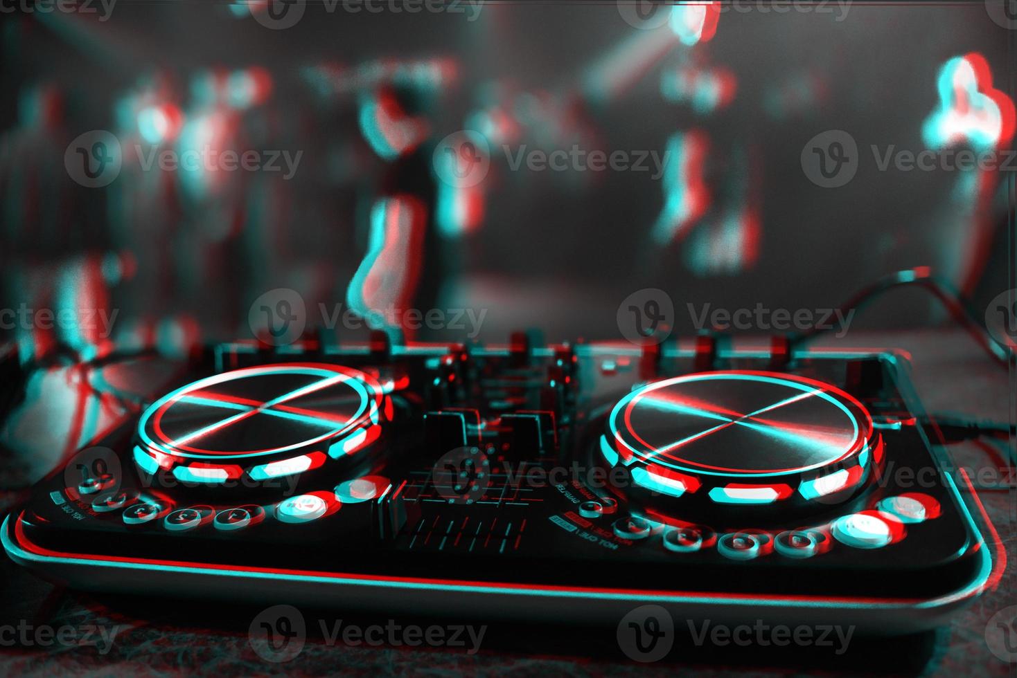 DJ console for mixing music with blurry people dancing at a nightclub party. Black and white with 3D glitch virtual reality effect photo