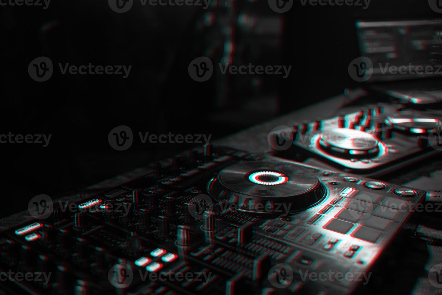 DJ console for mixing music with blurry people dancing at a nightclub party. Black and white with 3D glitch virtual reality effect photo