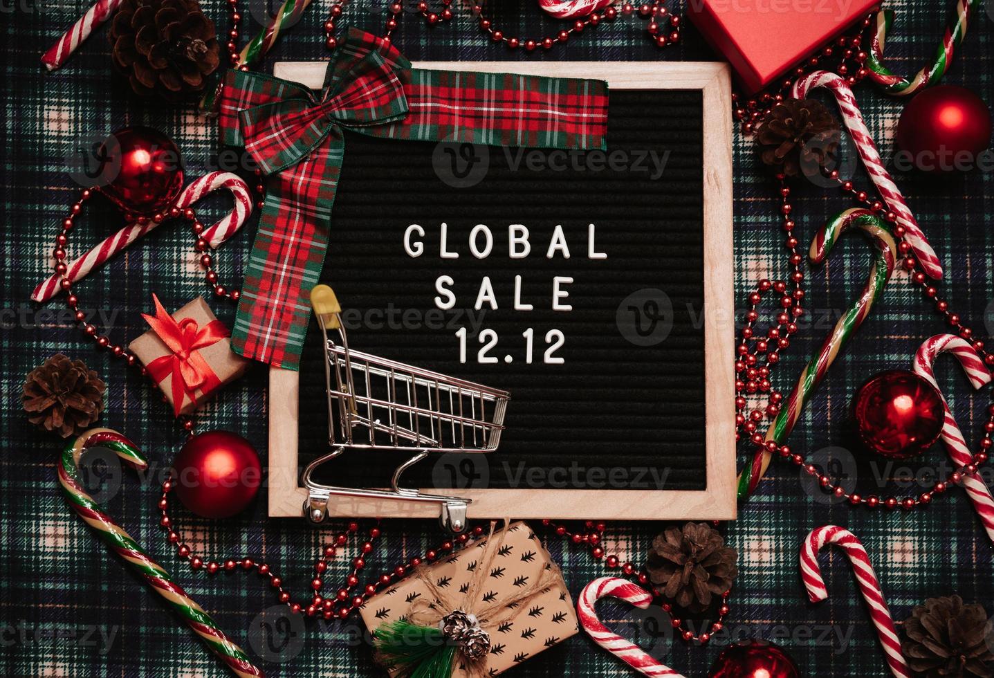 The text of the sale 12.12 on the Christmas decor letter board with a credit card and a mini grocery cart. Design to promote the winter sale at the end of the year. Top view. photo