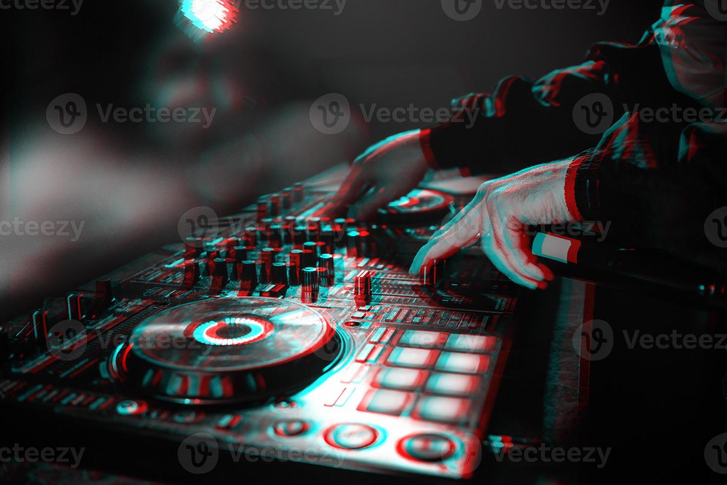 DJ console for mixing music with hands and with blurred people at a night club. Black and white with 3D glitch virtual reality effect photo