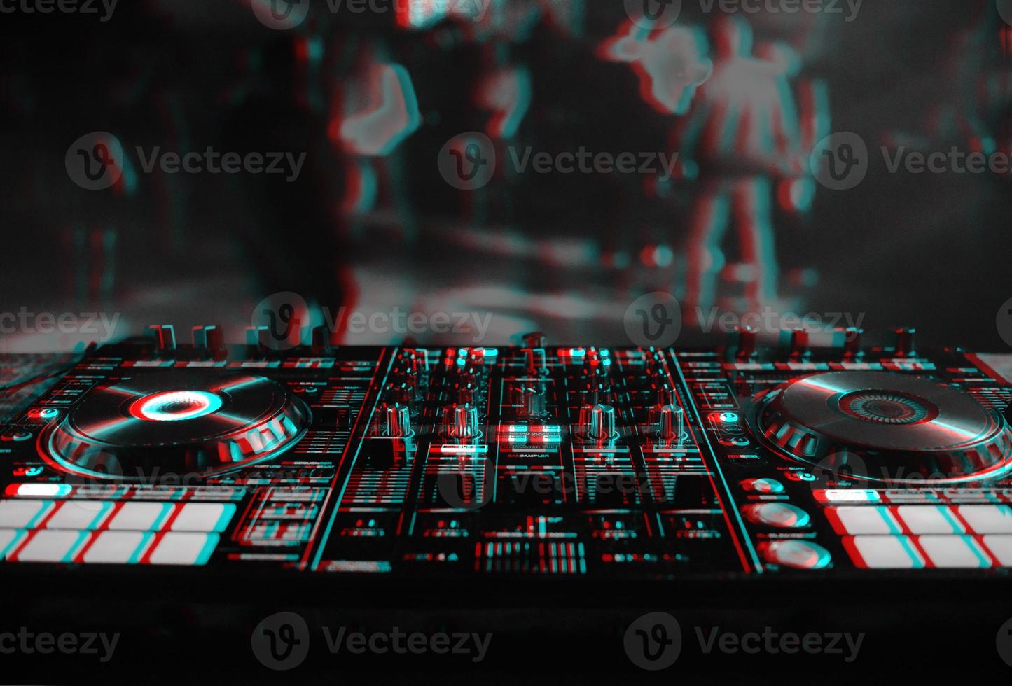 DJ console for mixing music with blurry people dancing at a nightclub party. Black and white with 3D glitch virtual reality effect photo