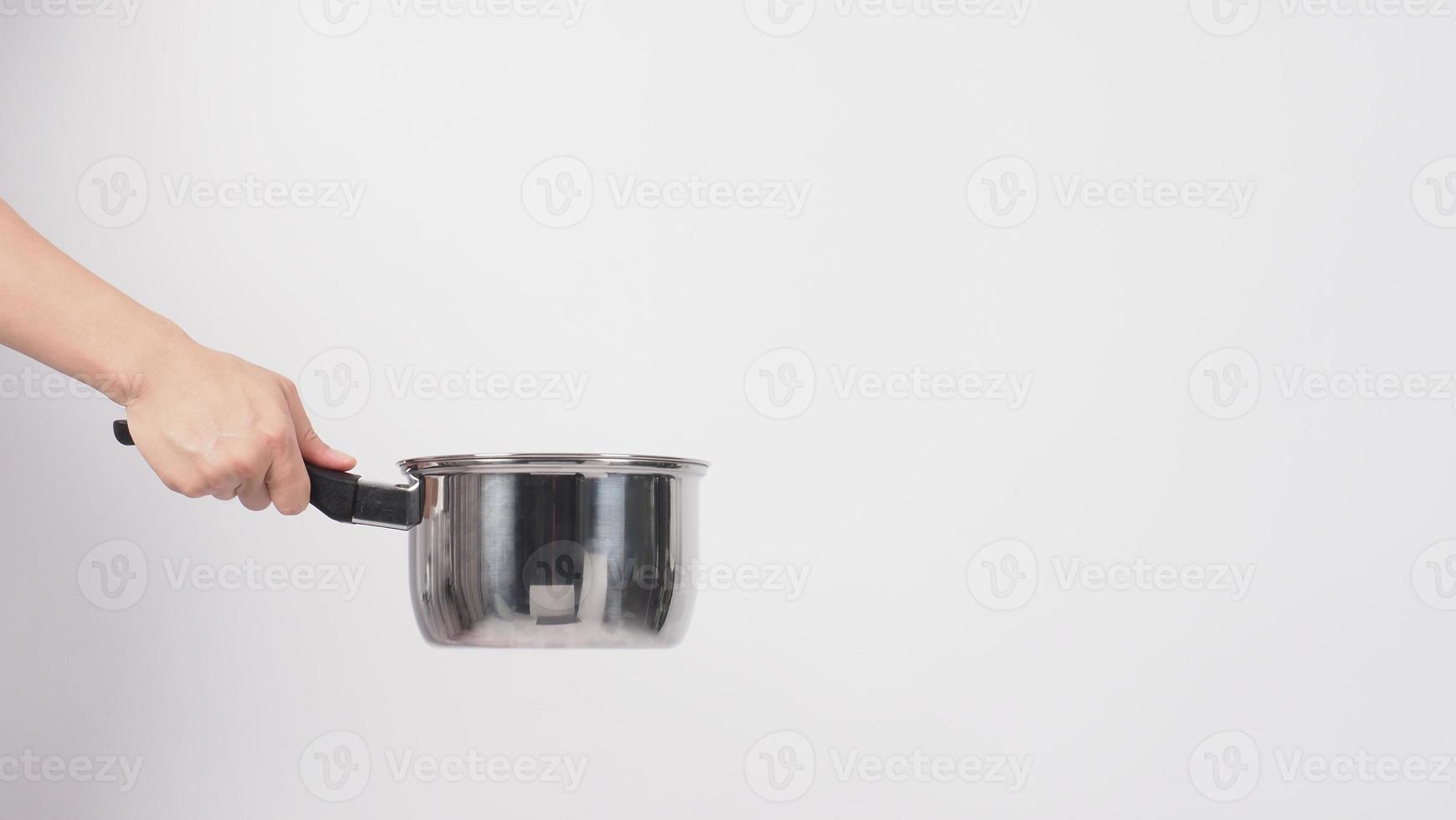 Pot cleaning Man hand on white background cleaning the non stick pot with handy dish washing sponge which yellow color on the soft side and green on hard side for hygiene after cook. Electric pot photo