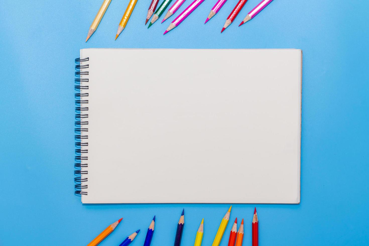 Collor wooden pencils in row isolated on bluebackground. Top view with copy space. photo