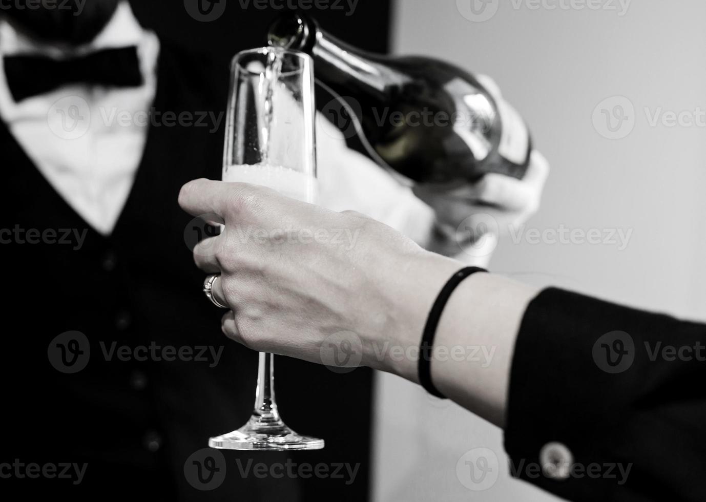 waiter pouring champagne into a flute. photo