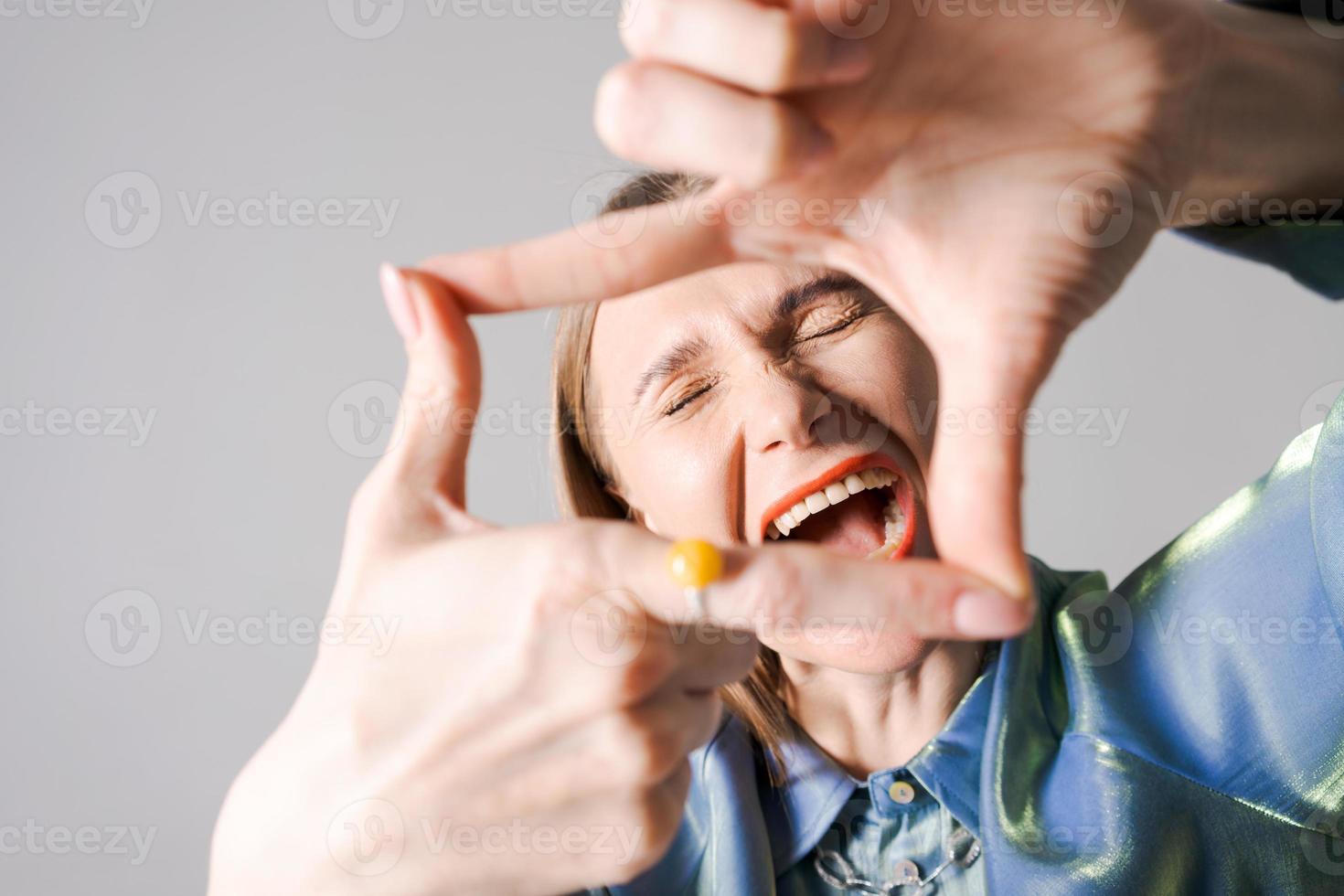 cerca arriba retrato emocional encantador alegre mujer con brillante labios espectáculo mano foto