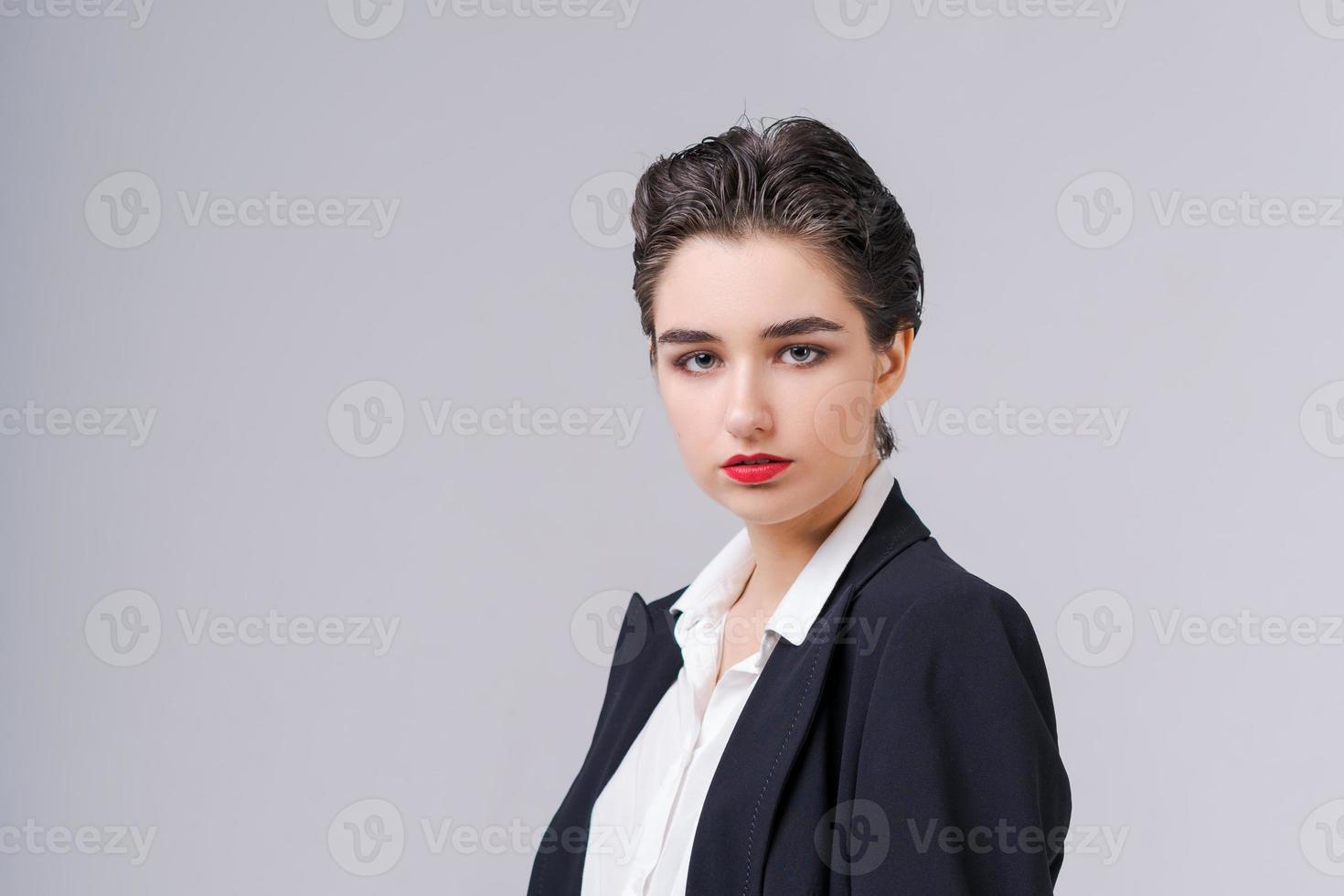 Stylish young business woman in black suit looks confidently into camera. photo