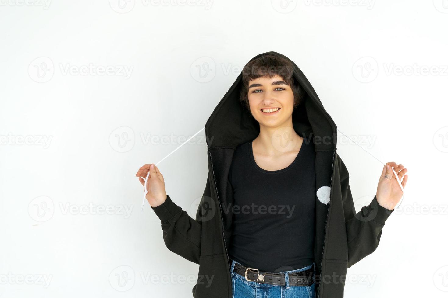 Young woman with black short hair posing in studio. Dressed in a black photo