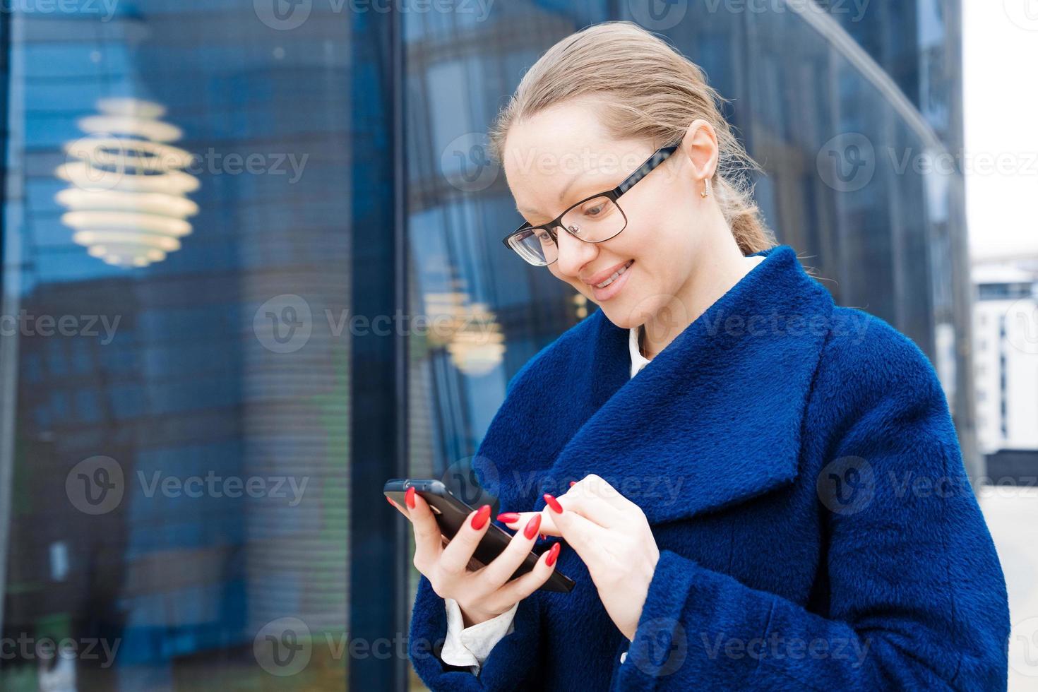 Professional business woman using technology outside, happy female manager photo
