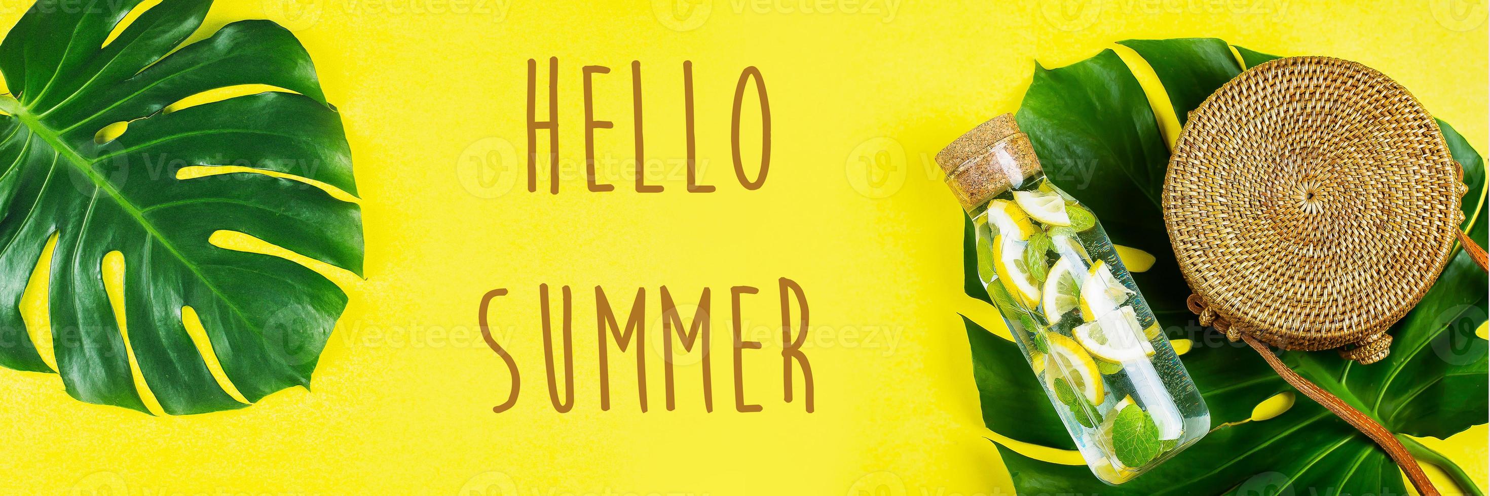 Hello Summer Banner for website. Round rattan bag and glass bottle with lemonade and Monstera leaf photo