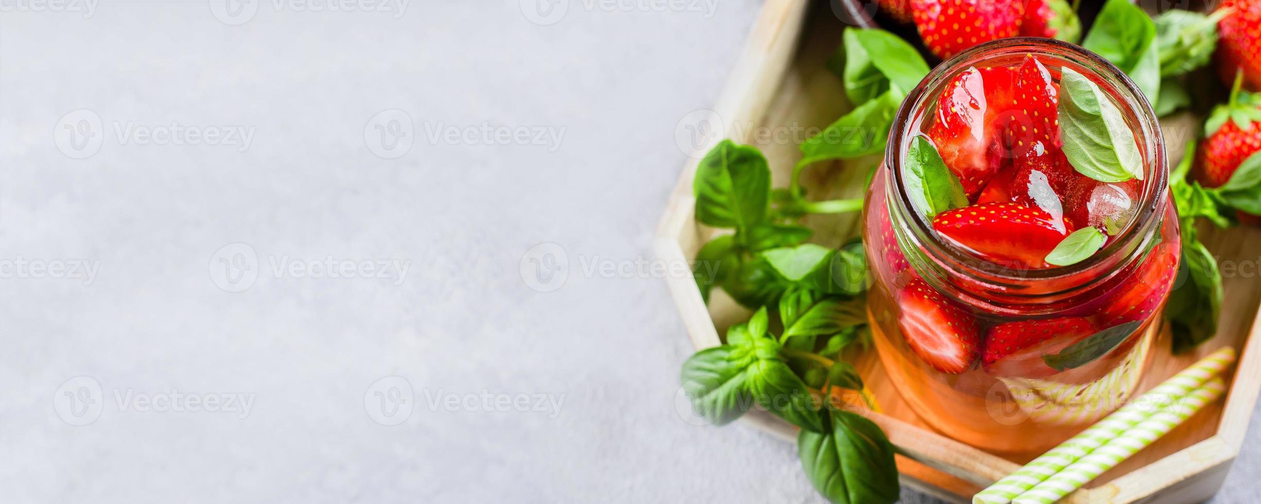 Summer Food and Drink. Lemonade with Strawberry and Basil in mason jar on wooden tray on table photo