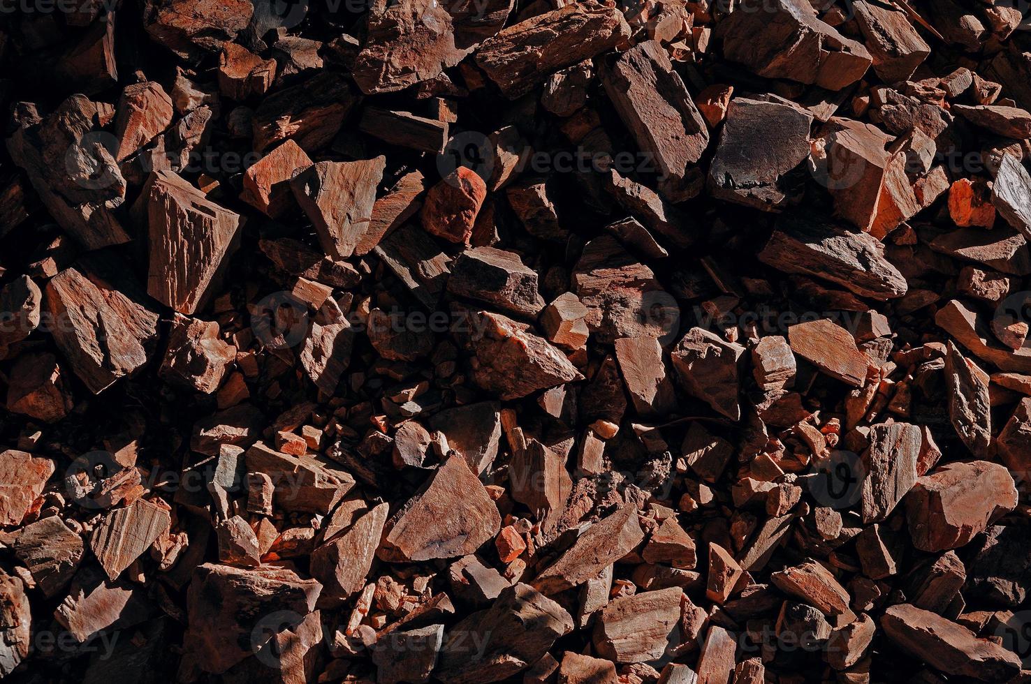 Top view on stones rocks spiky close up structure illuminated by the sun, texture for background photo