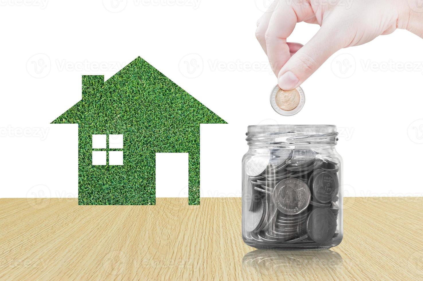 Hand putting coin into glass container of buying a new house - saving money for future concept,house savings coins. isolated on white background photo
