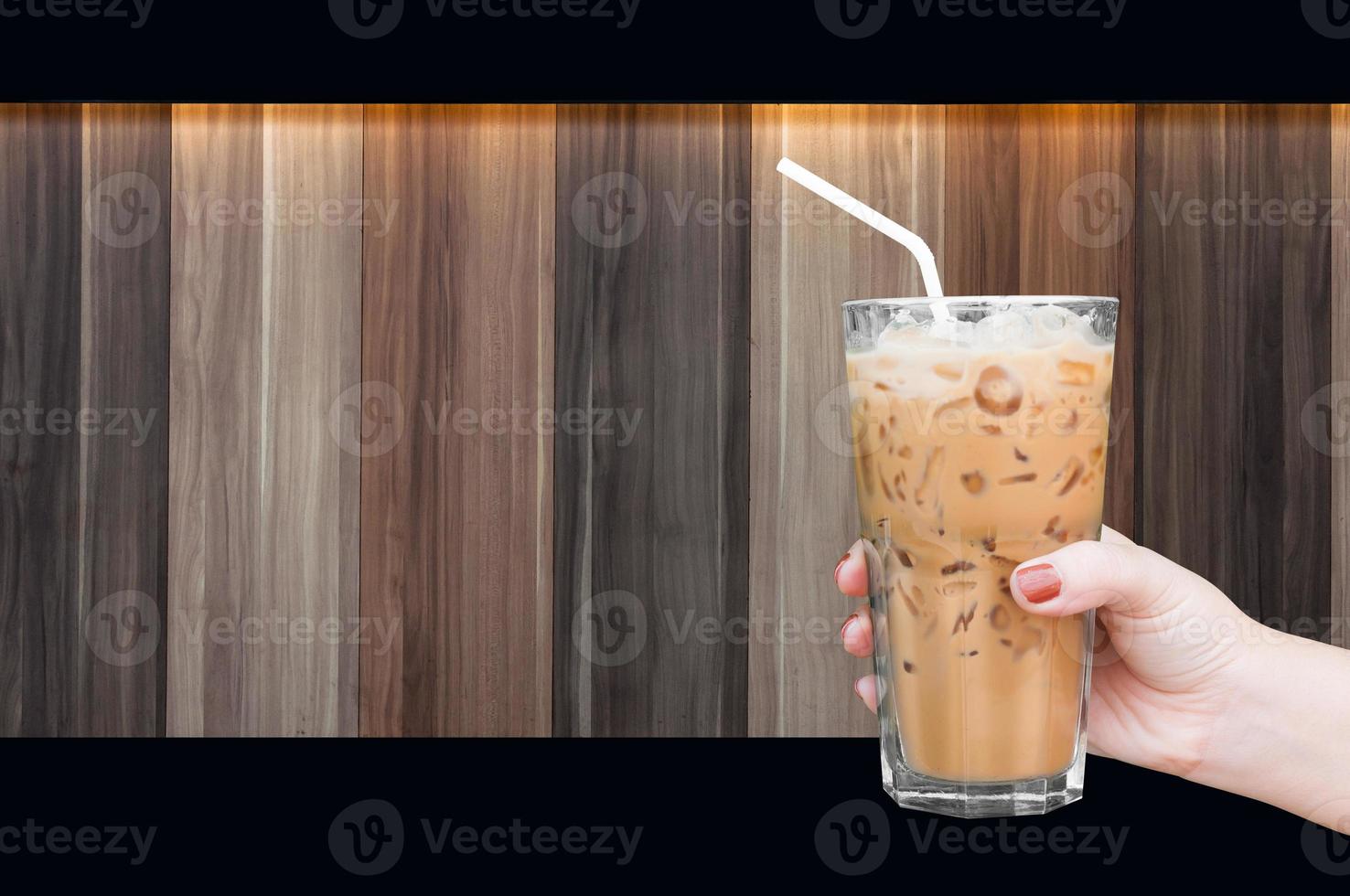 woman hand holding the glass iced coffee on wooden background,Iced latte coffee photo